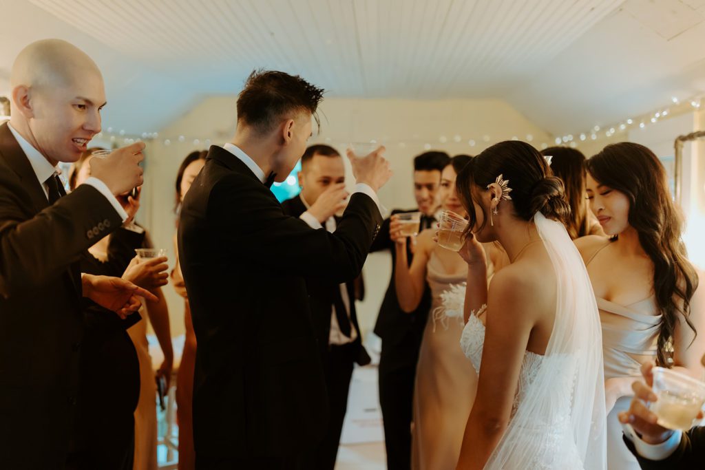 Couple and their friends toasting after the ceremony in the getting ready suite with champagne